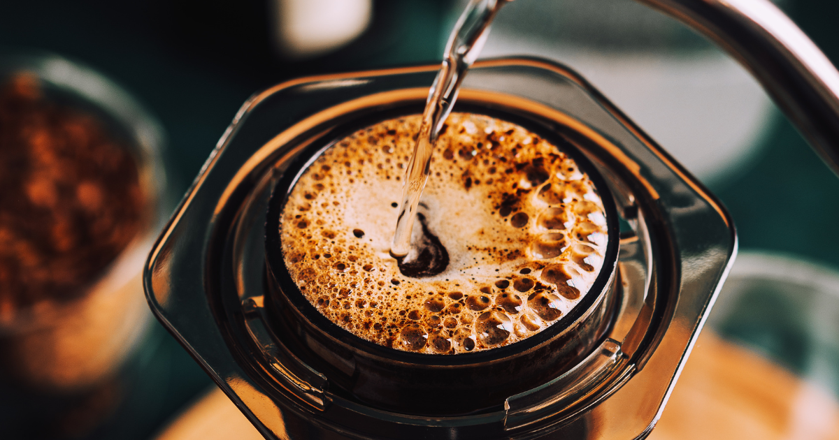 Pouring boiling water into an Aeropress with coffee grounds blooming - OlegKov – Getty Images