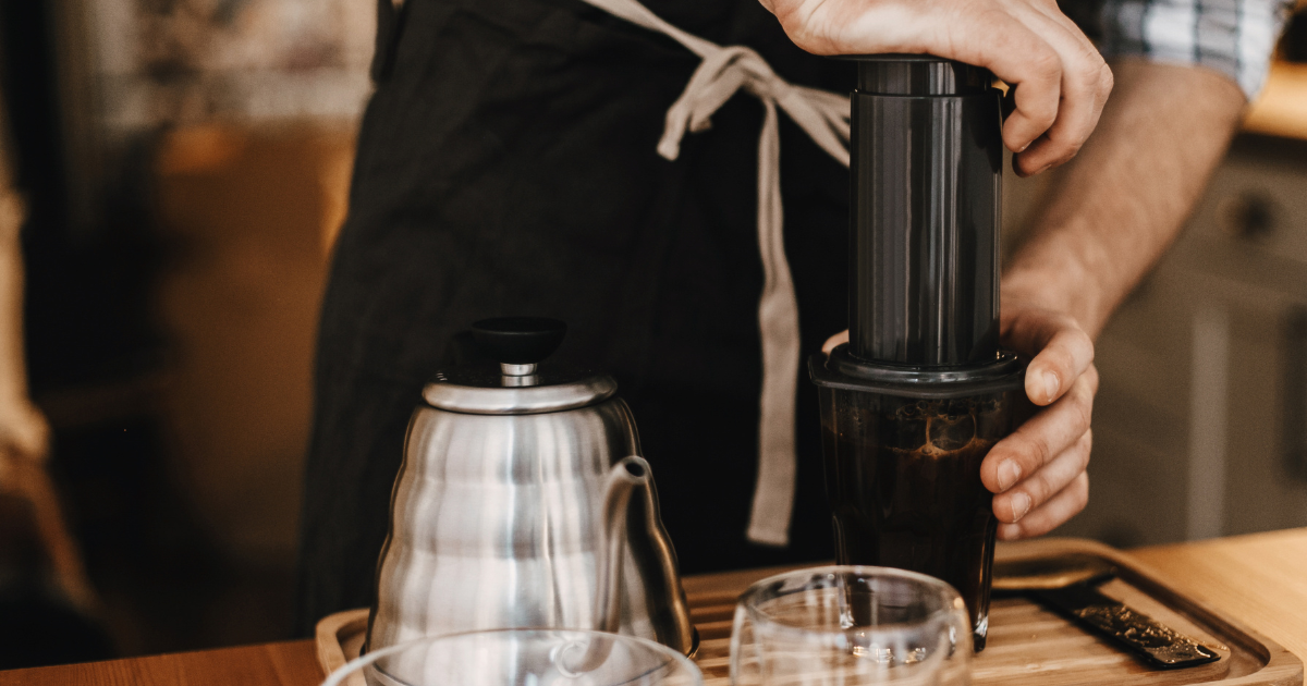 Plunging an Aeropress at a coffee bar - Bogdan Sonjachnyj 