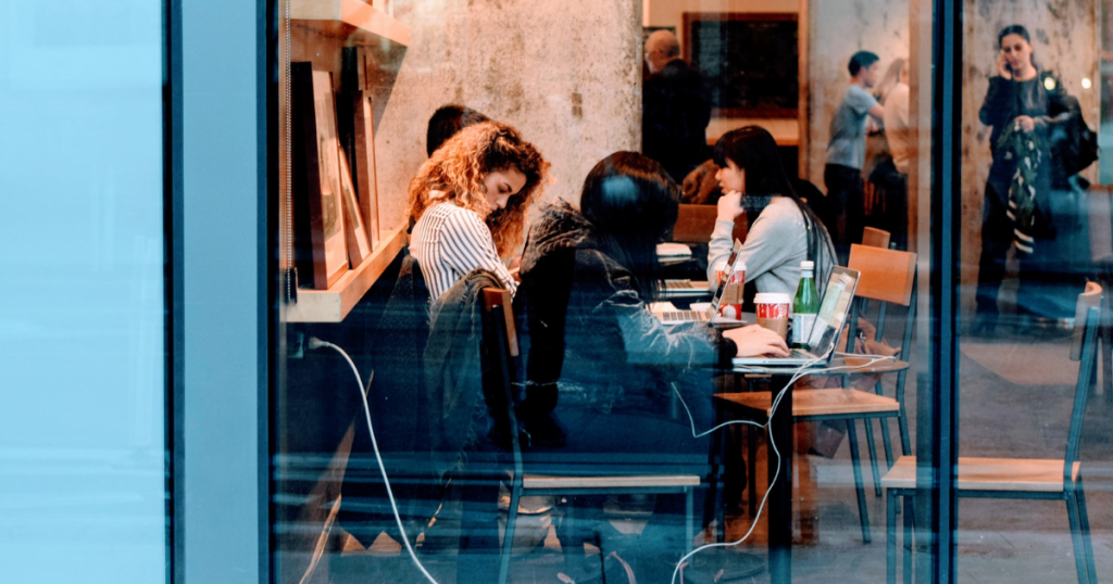 Friends working with computers in a Coffee Shop by Pexels _ Pixabay - Genuine Origin Coffee Looking in through a coffee shop window one sees people at a table with open laptops and cups of coffee