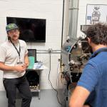 Brian Nutsch from Huckleberry explains a coffee roasting machine in a workshop