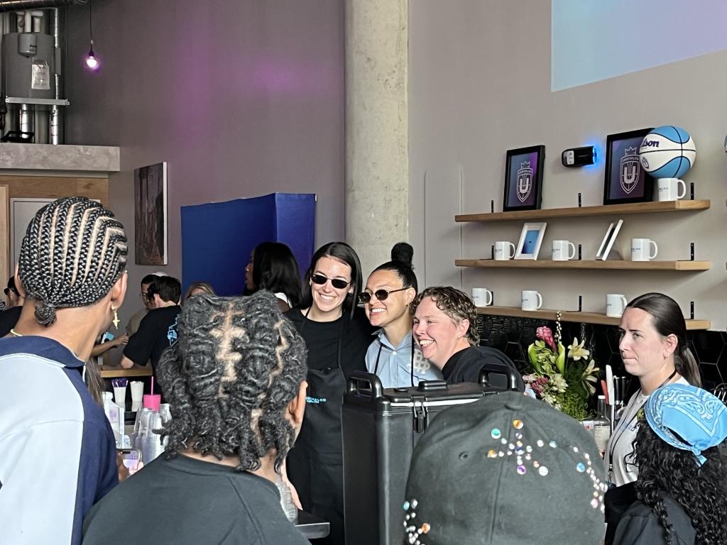 Bridget Carlton and Kayla McBride pose for pictures with fans in a busy cafe 