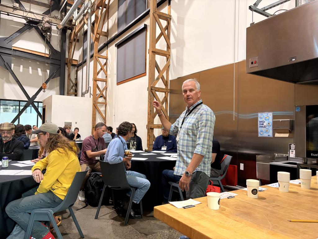 Scott Merle of La Minita speaking to a room of seated participants at Roast Summit Portland