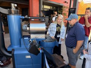 A woman and man looking at a blue San Franciscan 3 kg roaster