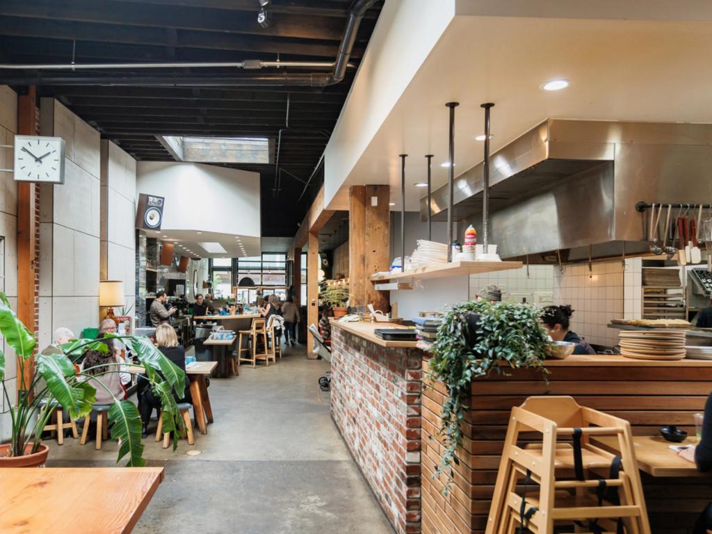 A minimalist modern cafe with green plants and a long corridor 